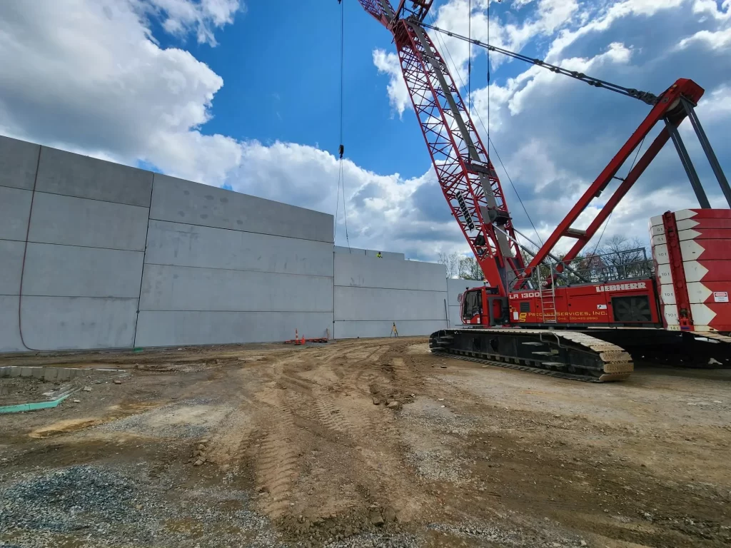 Precast Services using a crane to erect large precast panels.
