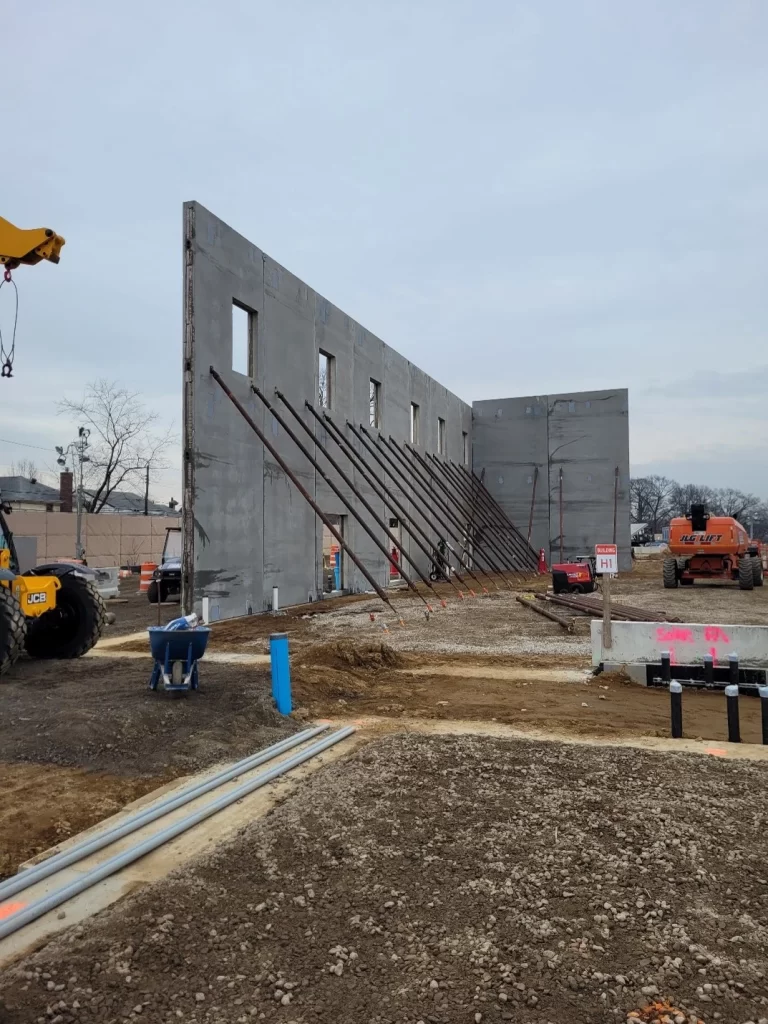 Precast services using structural support to hold precast panels upright.