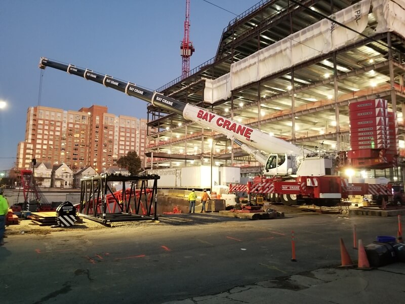 Well lit night view of the construction site of Rutgers. Lights within structure are turned on.
