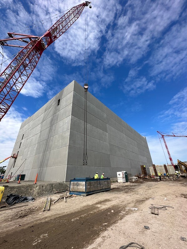 Ground view of Point Liberte apartment parking garage with cranes in both the foreground and background.
